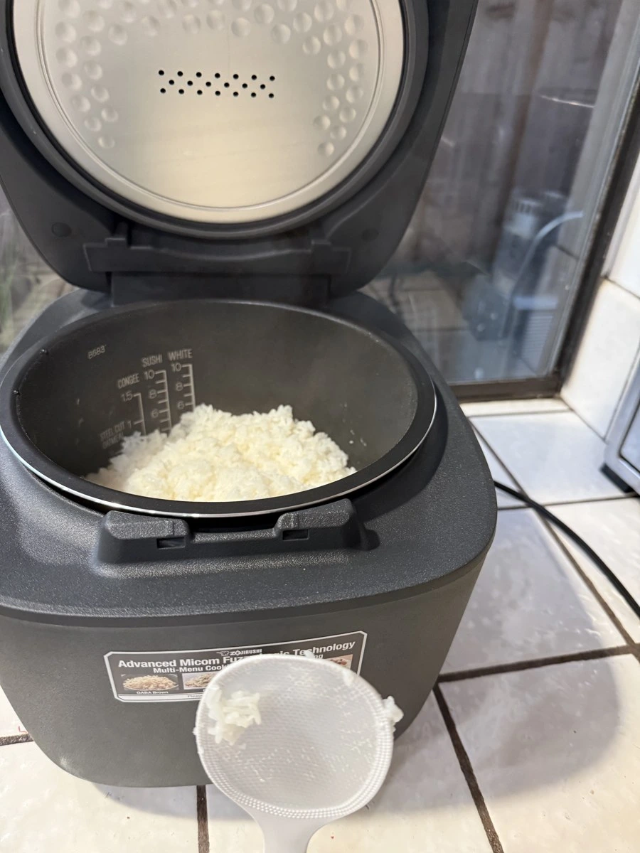 Inside of a black rice cooker inner pot showing cup water markings